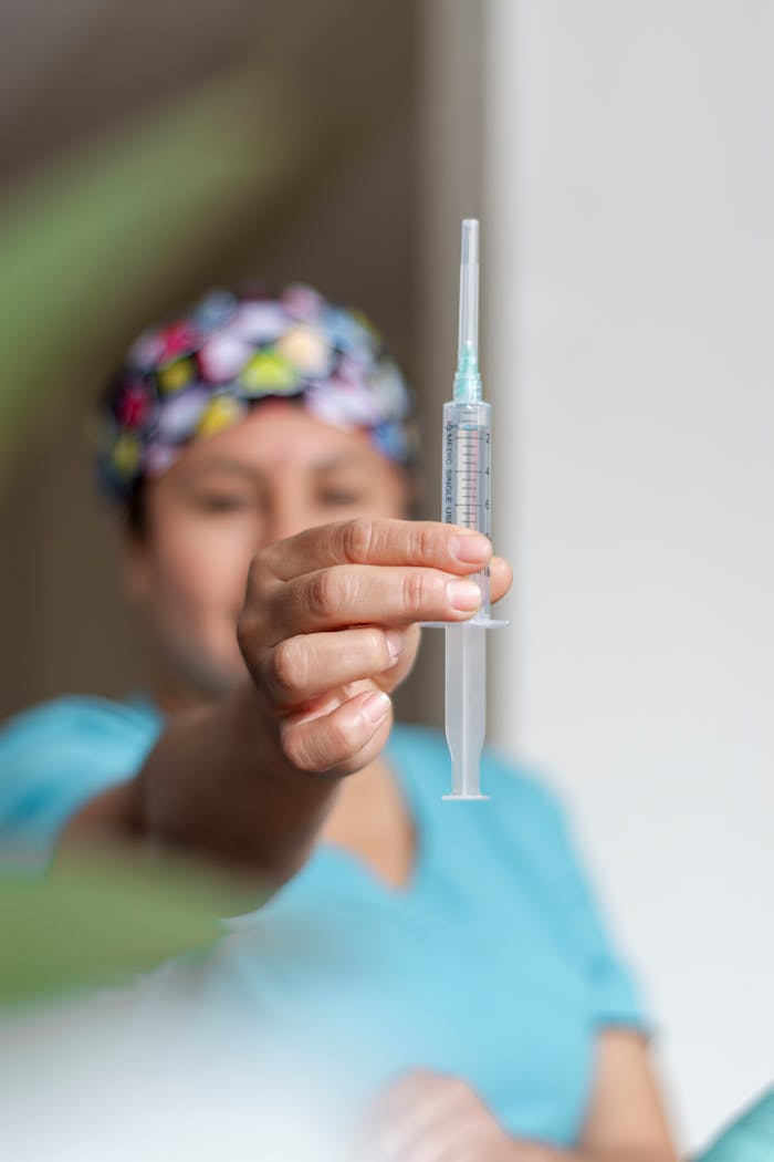 heros-img Close-up of a healthcare professional presenting a syringe with a blurred background.